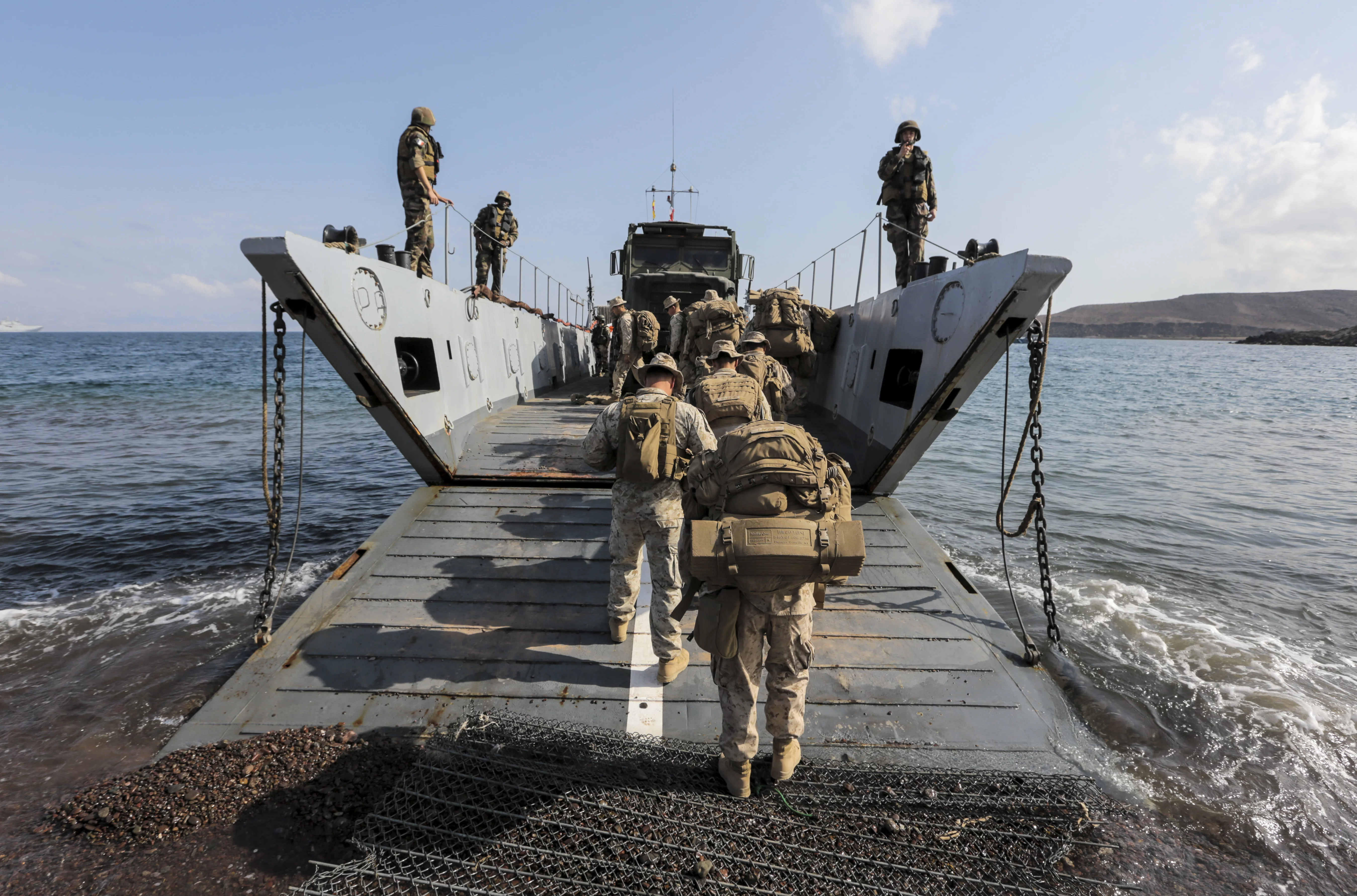 Des Marines embarquent à bord d'un chaland de débarquement (CTM) de la marine nationale pour rejoindre le BPC Tonnerre