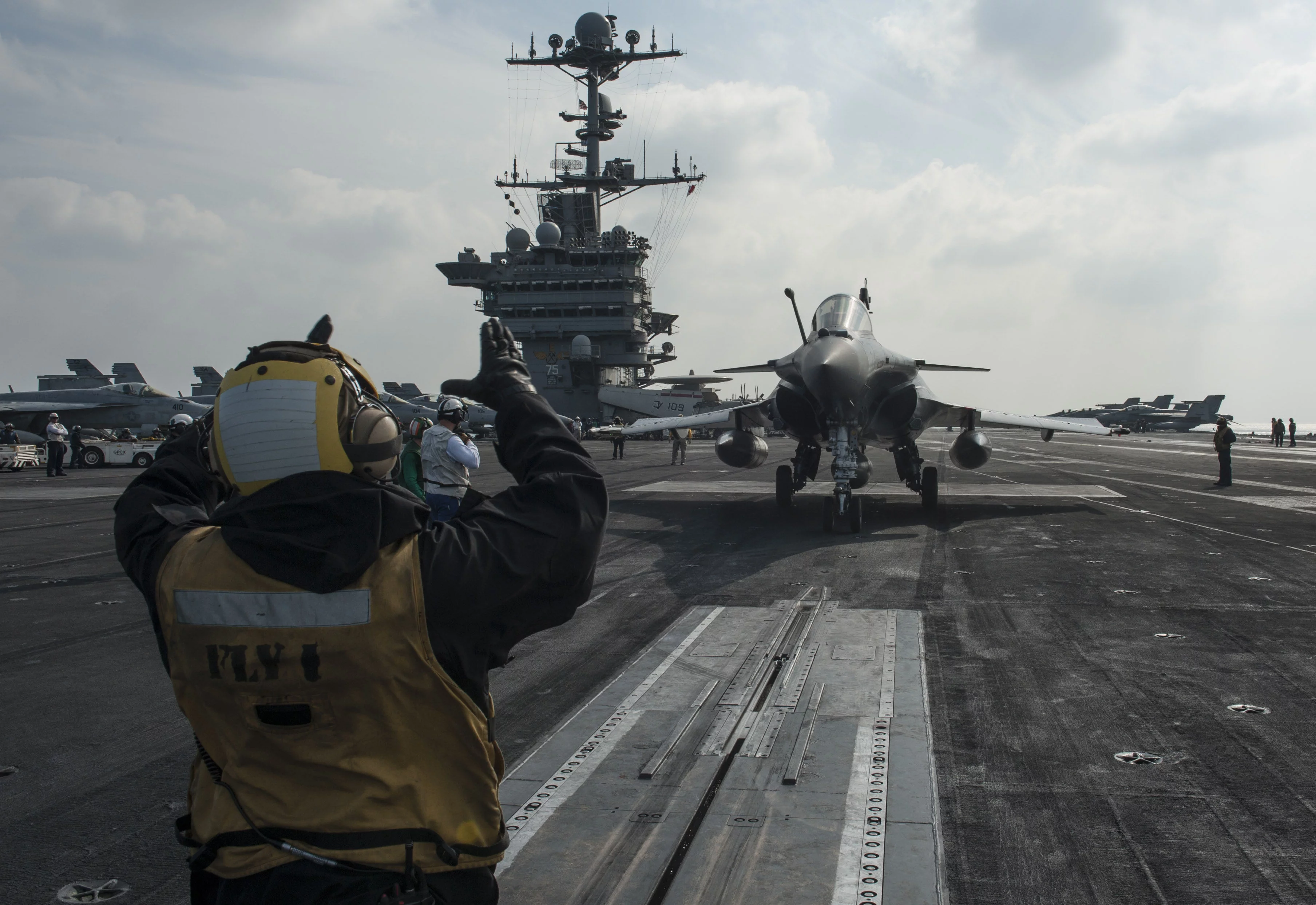 Un marin américain guide un Rafale vers la catapulte du porte-avions Harry S. Truman