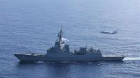 Un avion de surveillance maritime Falcon F200 Gardian survole la frégate australienne Brisbane