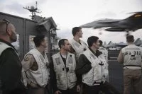 Des pilotes du Charles de French assistent à l'appontage d'avions depuis la plateforme de signalisation du porte-avions USS Harry S. Truman