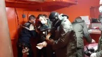 Un membre de l'équipage du Forbin s'équipe d'une combinaison NRBC (Nucléaires, radiologiques, biologiques et chimiques)