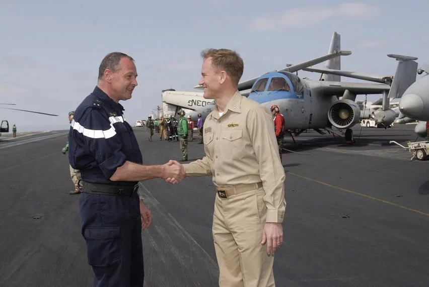 Le contre-amiral Xavier Magne est accueilli par le contre-amiral Kevin Quinn sur le pont d'envol du porte-avions USS John C. Stennis